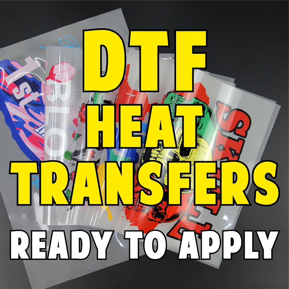 Promotional image for Gravity Designs showing several DTF heat transfer films with colorful custom designs. Large yellow text reads "DTF HEAT TRANSFERS" and white text at the bottom says "READY TO APPLY" against a dark background.